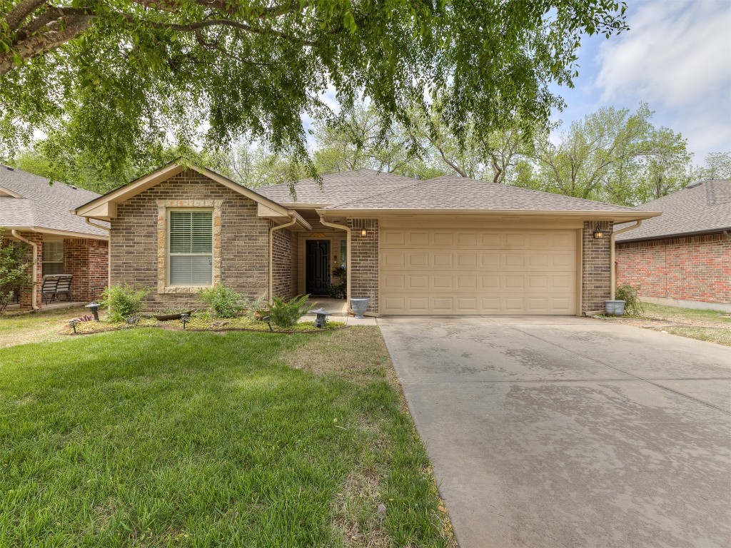 2924 Woodcrest Creek Drive, Norman, OK 73071 ranch-style house with a front yard and a garage