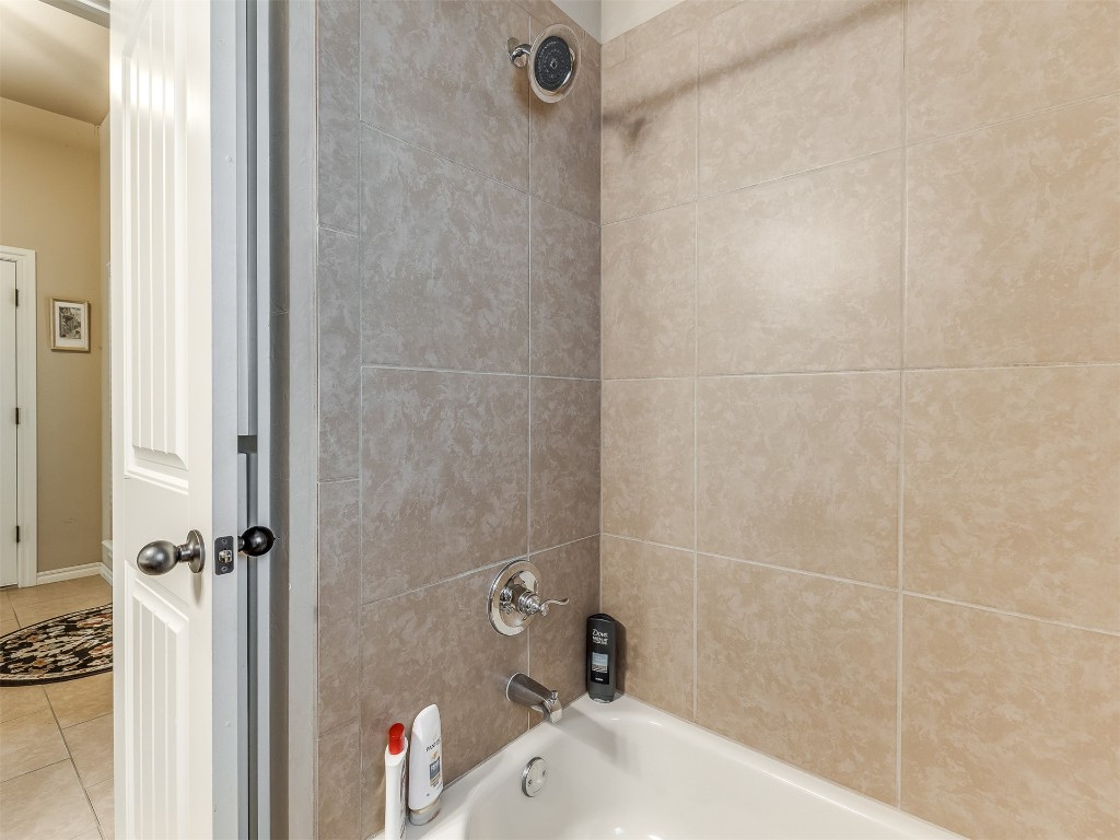 2924 Woodcrest Creek Drive, Norman, OK 73071 bathroom featuring tiled shower / bath and tile floors