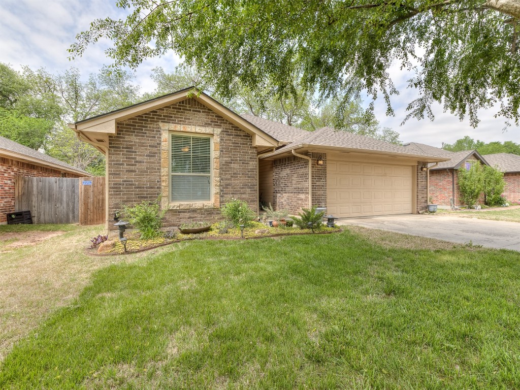 2924 Woodcrest Creek Drive, Norman, OK 73071 ranch-style home with a garage and a front yard
