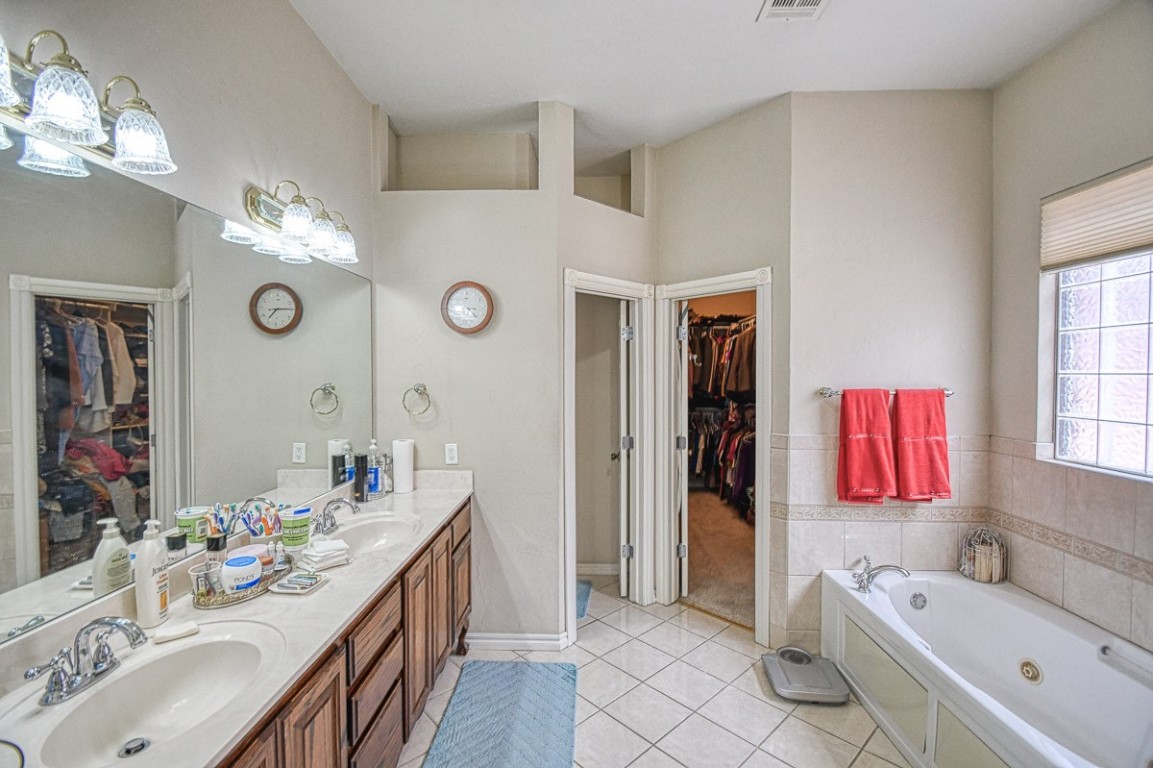 4508 Greystone Lane, Norman, OK 73072 bathroom with tile flooring, dual sinks, oversized vanity, and a washtub