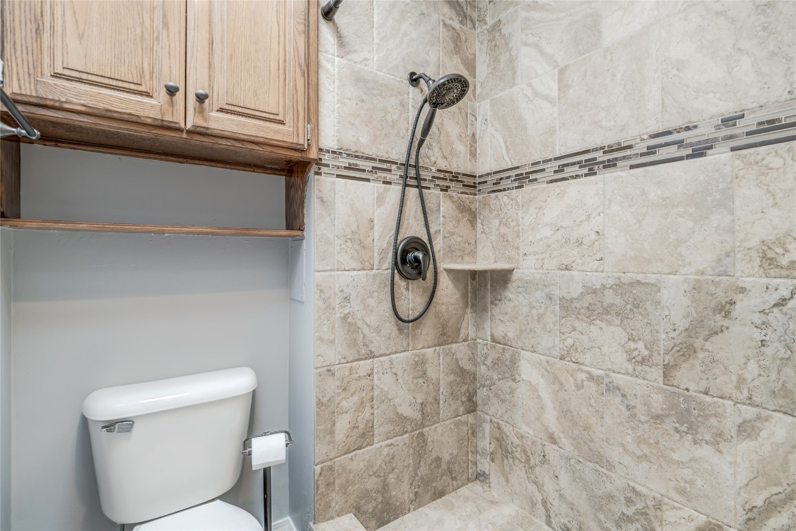 208 Crown Colony Court, Edmond, OK 73034 bathroom with toilet and a tile shower