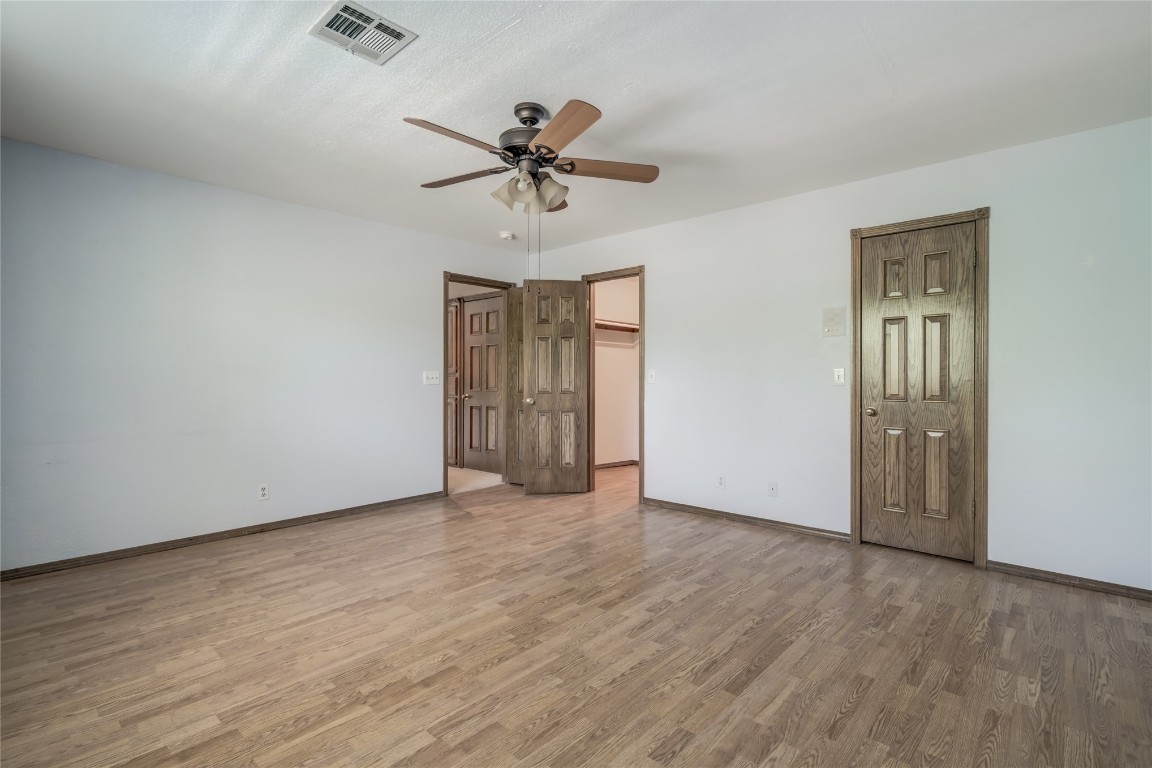 208 Crown Colony Court, Edmond, OK 73034 unfurnished bedroom with hardwood / wood-style flooring and ceiling fan