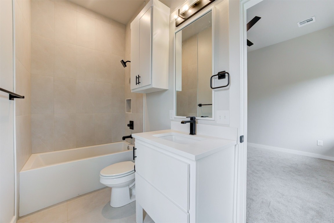 808 N Douglas Avenue, Oklahoma City, OK 73106 full bathroom featuring tiled shower / bath, toilet, oversized vanity, and tile flooring