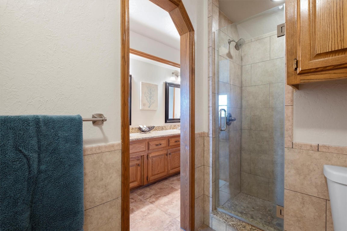 11517 Hackney Lane, Yukon, OK 73099 bathroom featuring a shower with shower door, toilet, tile floors, and vanity