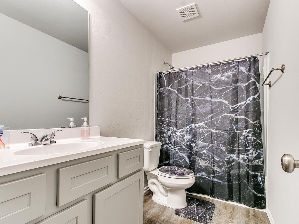 1016 S Appaloosa Lane, Mustang, OK 73064 bathroom with hardwood / wood-style floors, vanity, and toilet