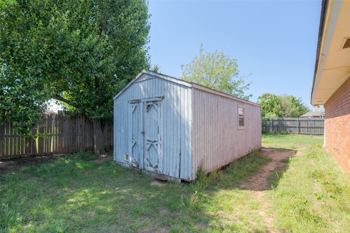 8117 N McKee Boulevard, Oklahoma City, OK 73132 view of shed / structure featuring a yard