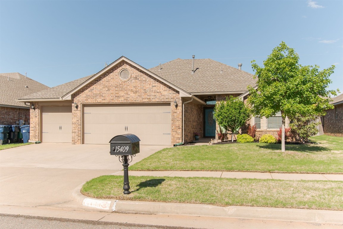 15409 Cardinal Nest Drive, Edmond, OK 73013 ranch-style house with a garage and a front lawn