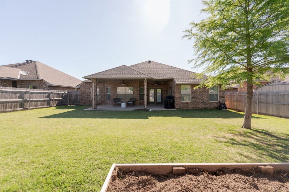 15409 Cardinal Nest Drive, Edmond, OK 73013 rear view of house with a patio area and a yard