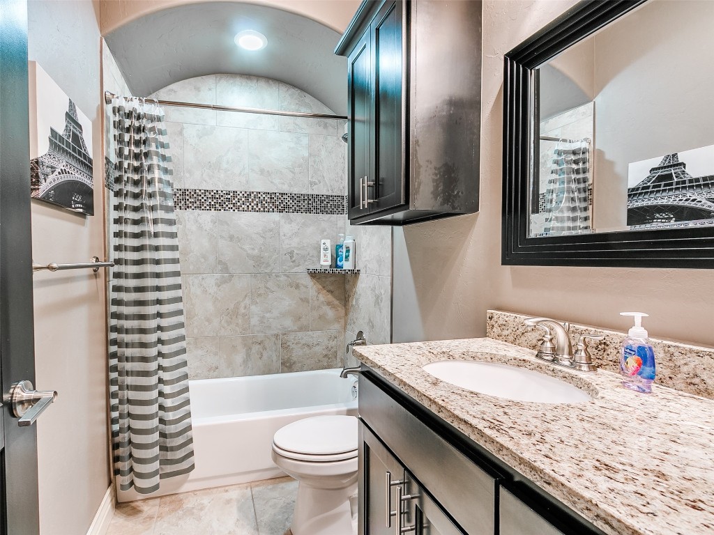 7208 NW 156th Street, Edmond, OK 73013 full bathroom featuring tile flooring, shower / tub combo, vanity with extensive cabinet space, and toilet
