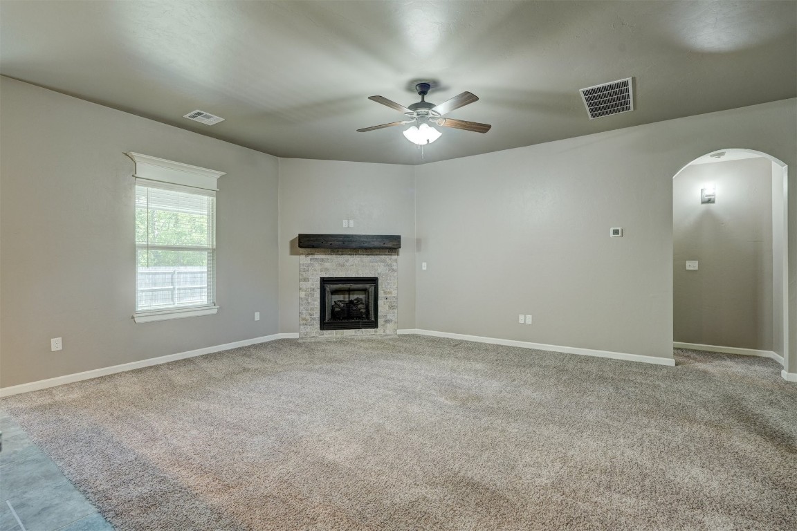 1727 W Blake Way, Mustang, OK 73064 unfurnished living room with ceiling fan and carpet flooring