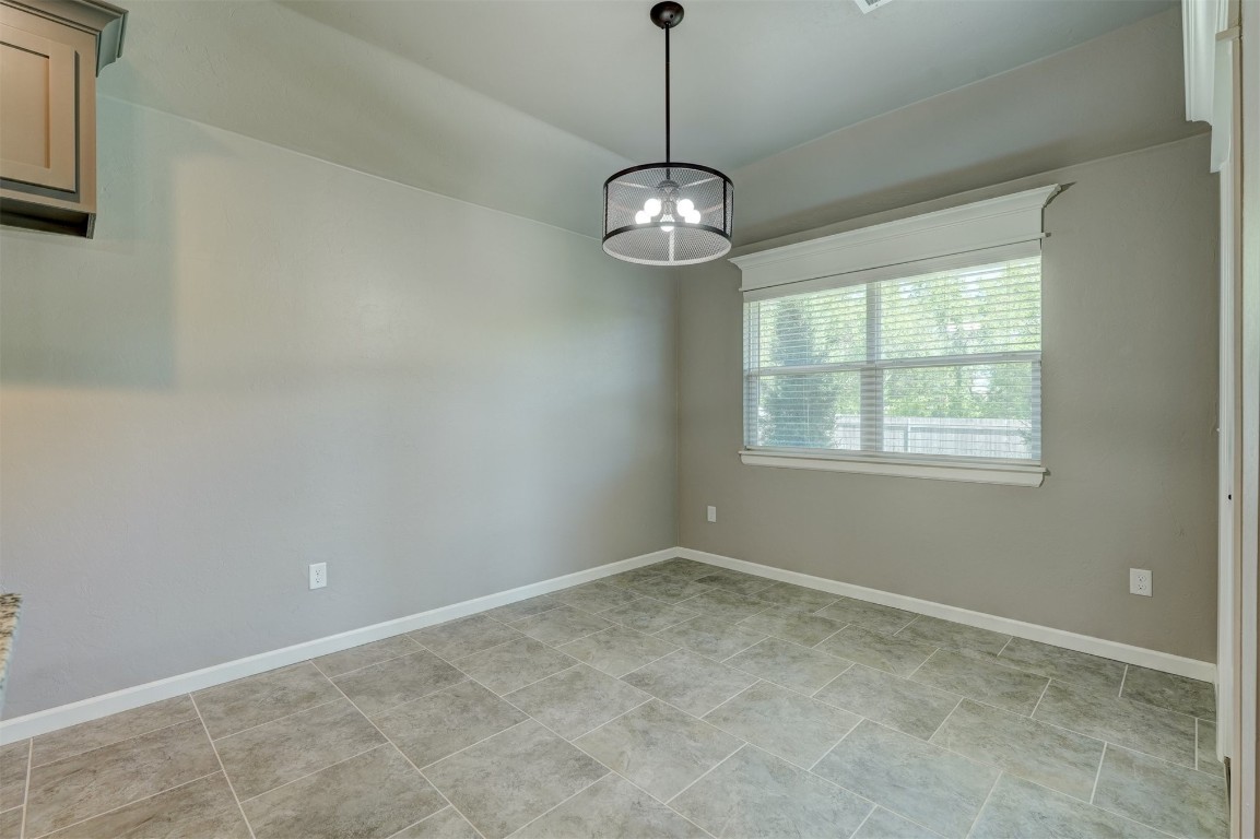 1727 W Blake Way, Mustang, OK 73064 spare room featuring light tile flooring and a chandelier
