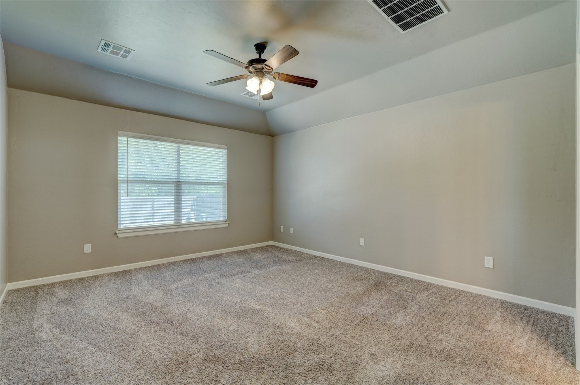 1727 W Blake Way, Mustang, OK 73064 carpeted spare room featuring vaulted ceiling and ceiling fan