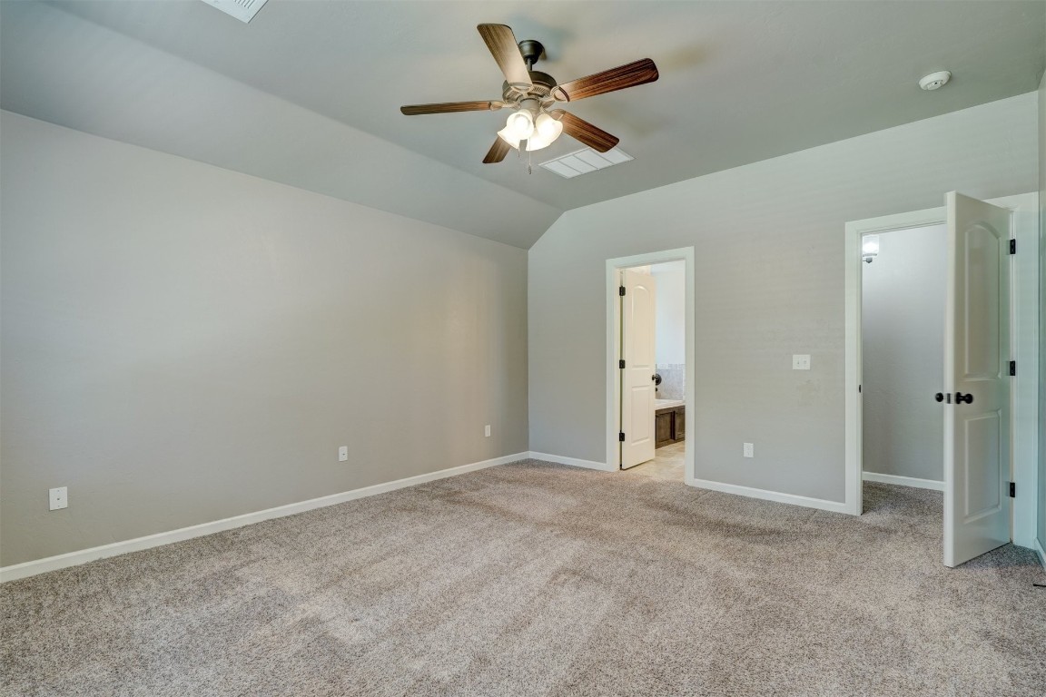 1727 W Blake Way, Mustang, OK 73064 unfurnished bedroom featuring light carpet, lofted ceiling, and ceiling fan