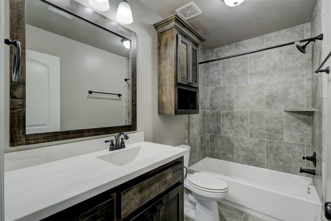 1727 W Blake Way, Mustang, OK 73064 full bathroom featuring tile flooring, tiled shower / bath, vanity with extensive cabinet space, and toilet