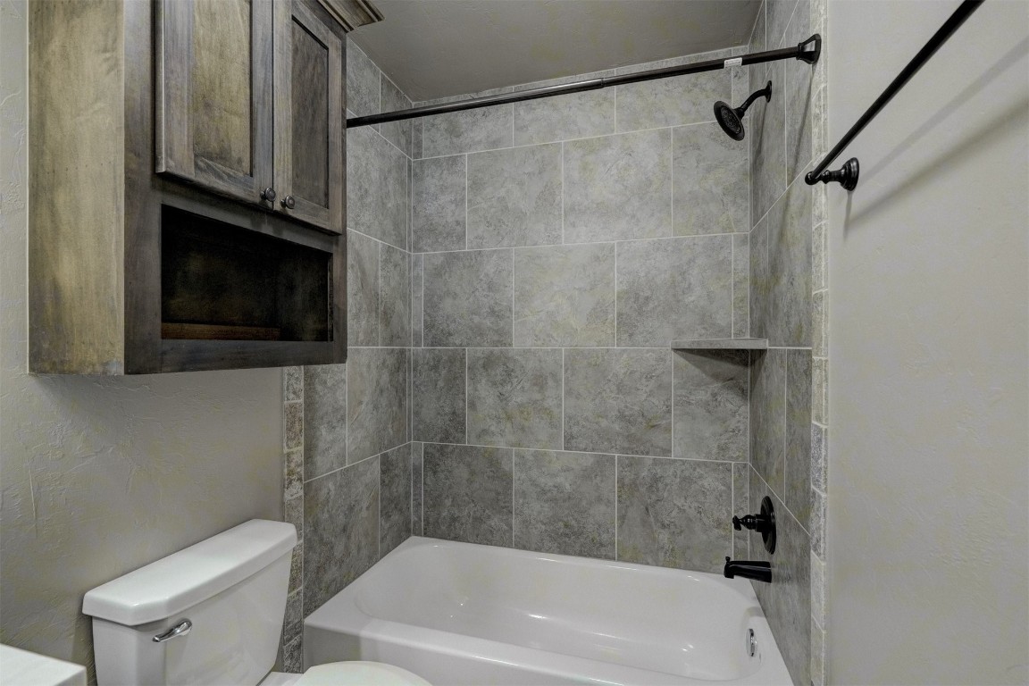 1727 W Blake Way, Mustang, OK 73064 bathroom with tiled shower / bath combo and toilet
