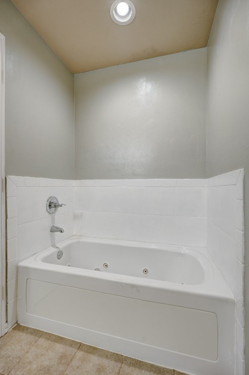 713 N Bobcat Way, Mustang, OK 73064 bathroom featuring a bathtub and tile floors