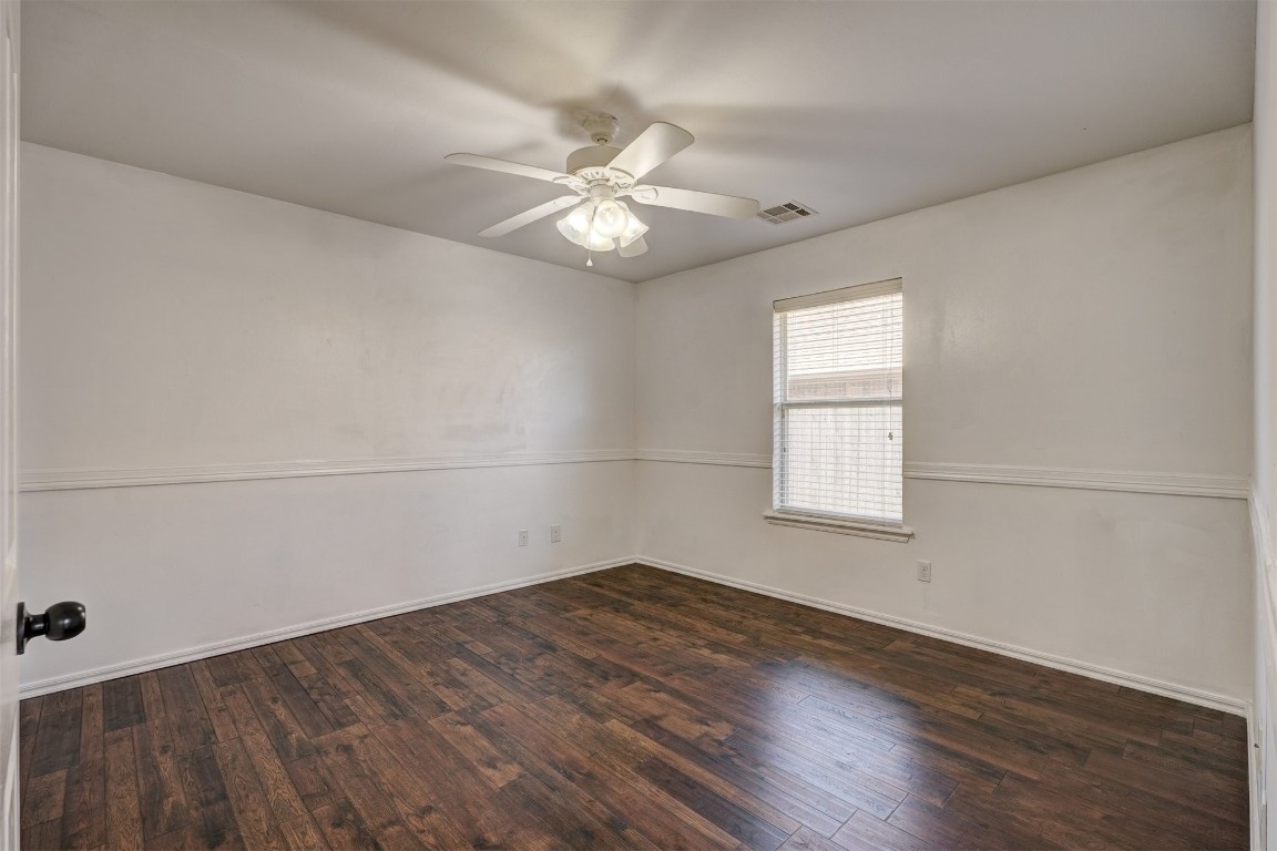 713 N Bobcat Way, Mustang, OK 73064 spare room featuring wood-type flooring and ceiling fan