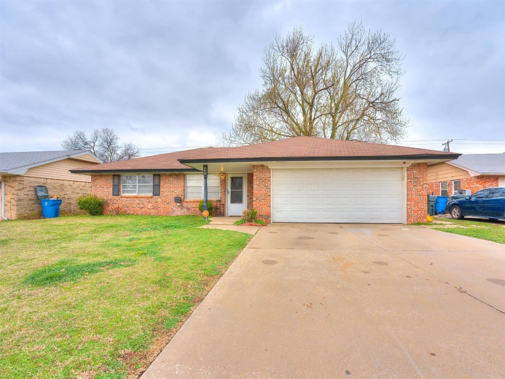 649 Juniper Avenue, Midwest City, OK 73130 ranch-style house with a garage and a front lawn