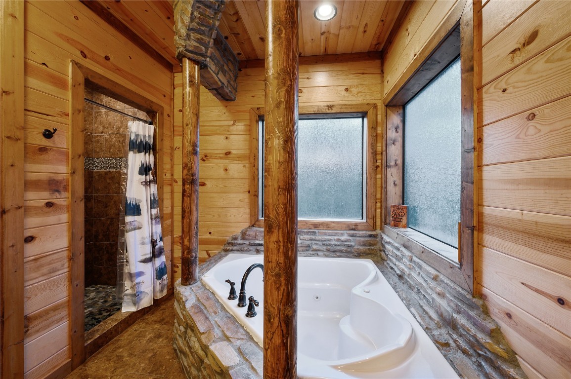 68 Stevens Road, Broken Bow, OK 74728 bathroom with independent shower and bath, wood walls, and wooden ceiling