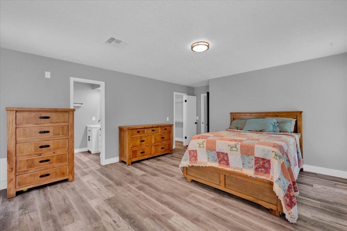 729 N Falcon Way, Mustang, OK 73064 bedroom featuring ensuite bath and hardwood / wood-style floors