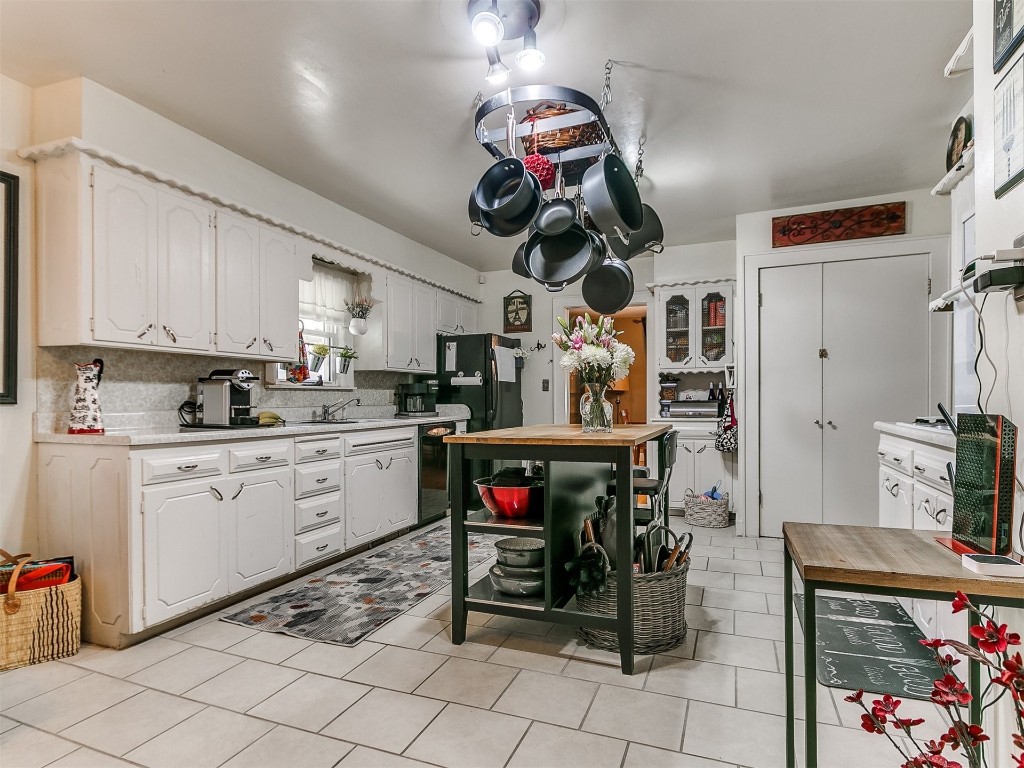 1800 NW 31st Street, Oklahoma City, OK 73118 kitchen featuring backsplash, black appliances, white cabinetry, and light tile flooring