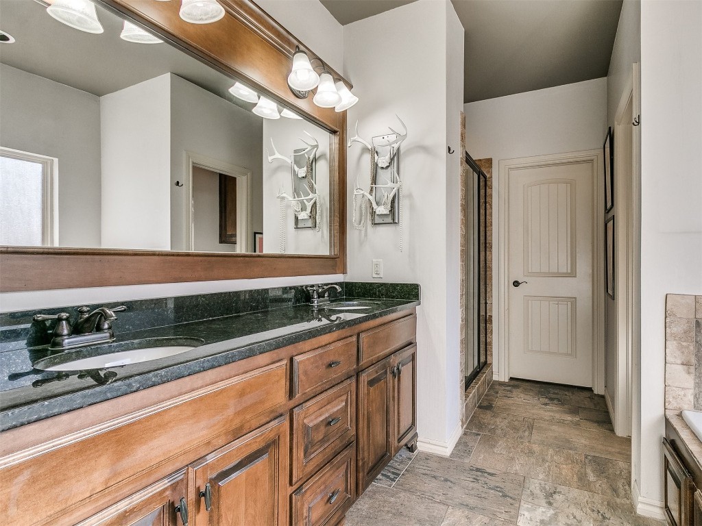 917 NW 195th Place, Edmond, OK 73012 bathroom featuring a shower with door, double vanity, and tile flooring