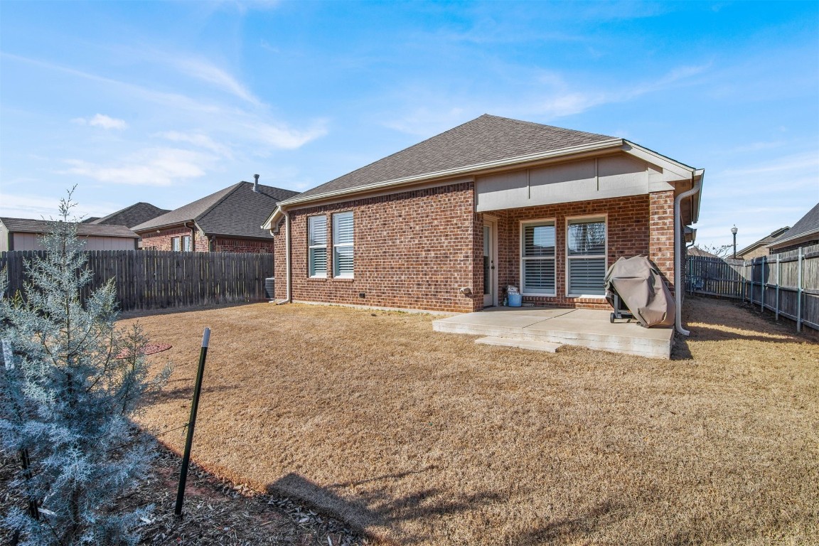 2404 NW 179th Terrace, Edmond, OK 73012 back of property featuring a patio area and a yard