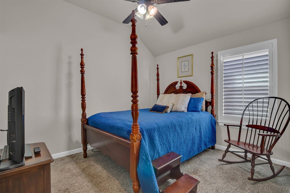 2404 NW 179th Terrace, Edmond, OK 73012 bedroom featuring ceiling fan, carpet floors, and vaulted ceiling