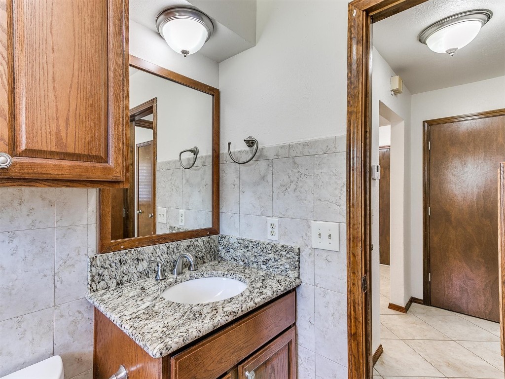3908 Corbett Drive, Del City, OK 73115 bathroom with tile floors, tile walls, and large vanity