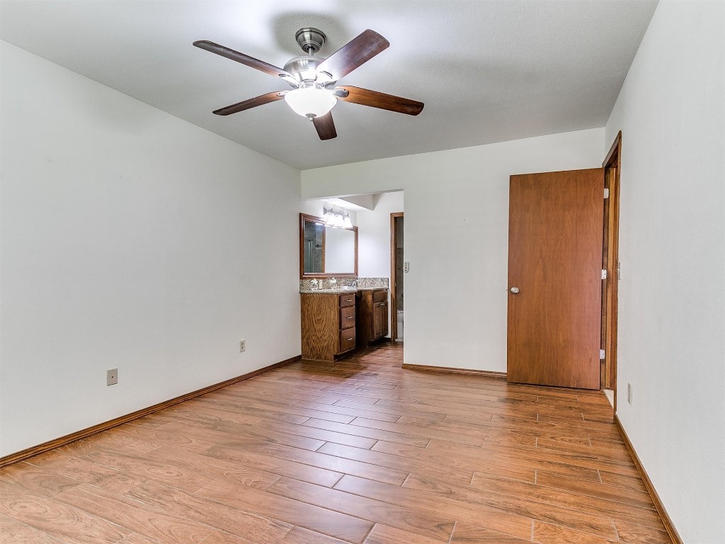 3908 Corbett Drive, Del City, OK 73115 unfurnished bedroom featuring hardwood / wood-style floors, ceiling fan, and ensuite bathroom