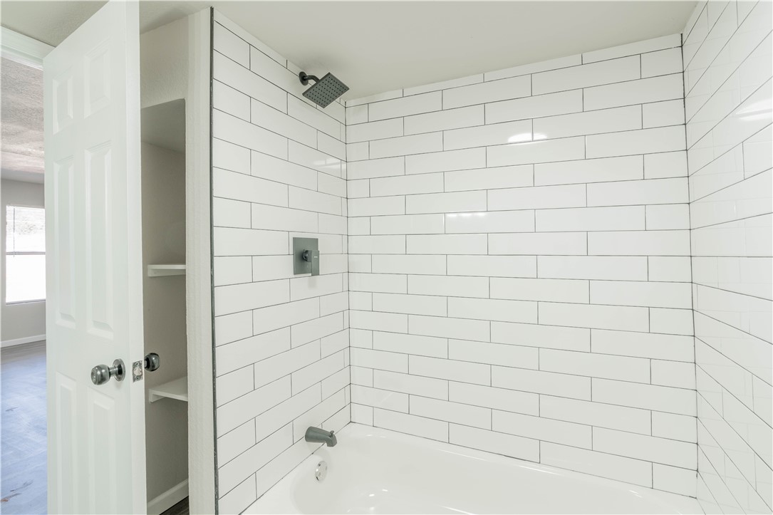 3820 Tranquill Terrace, Guthrie, OK 73044 bathroom featuring tiled shower / bath and hardwood / wood-style flooring