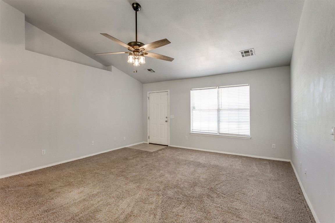 949 NW 15th Street, Moore, OK 73160 carpeted spare room featuring vaulted ceiling and ceiling fan