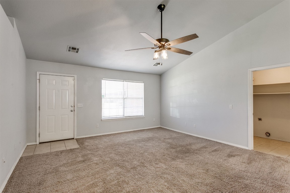 949 NW 15th Street, Moore, OK 73160 spare room featuring light carpet, lofted ceiling, and ceiling fan