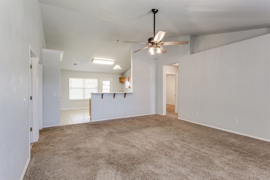 949 NW 15th Street, Moore, OK 73160 carpeted empty room with high vaulted ceiling and ceiling fan