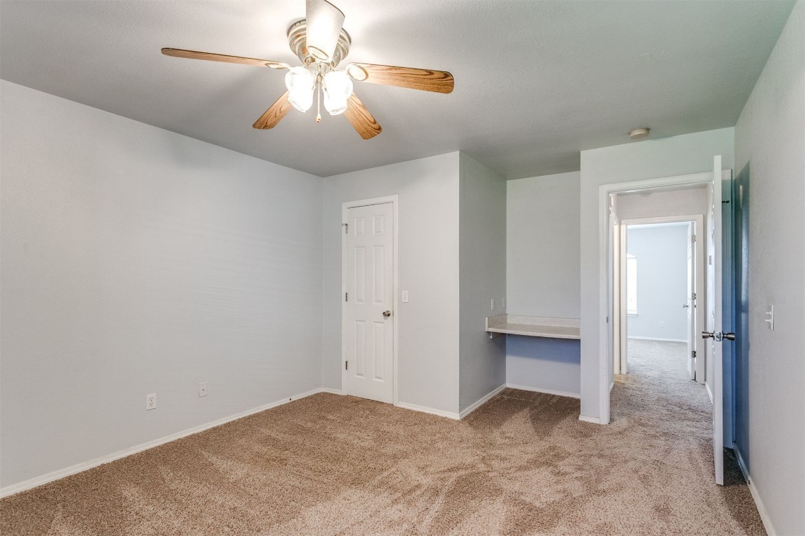949 NW 15th Street, Moore, OK 73160 unfurnished bedroom with a closet, ceiling fan, and light carpet