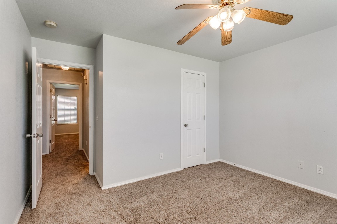 949 NW 15th Street, Moore, OK 73160 unfurnished bedroom featuring ceiling fan and light carpet