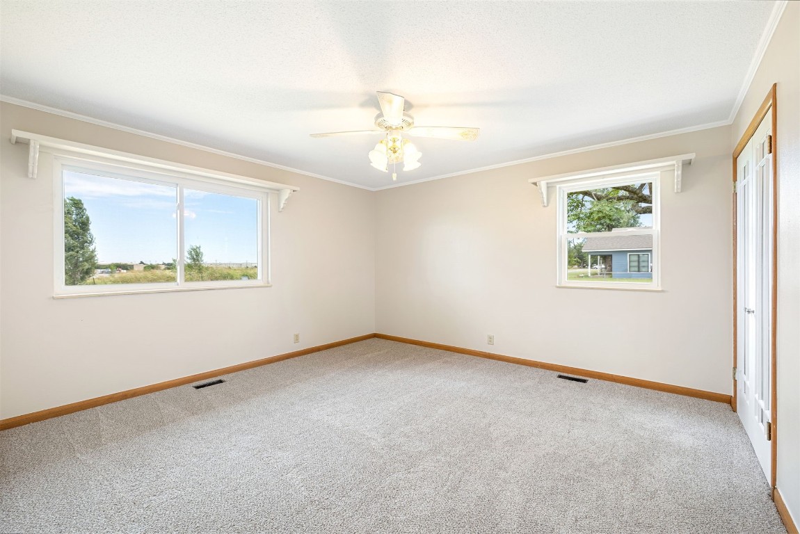 2500 S Choctaw Avenue, El Reno, OK 73036 spare room with ceiling fan, crown molding, and carpet flooring