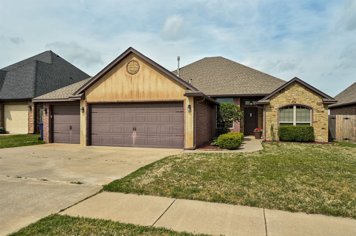 18125 Haslemere Lane, Edmond, OK 73012 ranch-style home with a front yard and a garage