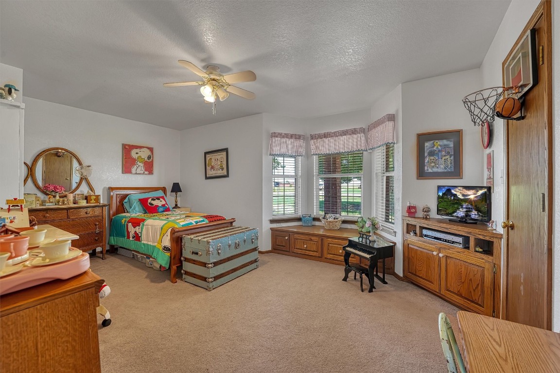 20290 E County Road 175, Elmer, OK 73539 carpeted bedroom with a textured ceiling and ceiling fan