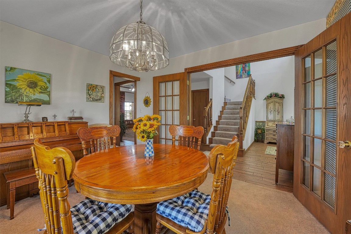 20290 E County Road 175, Elmer, OK 73539 dining room with light carpet and a chandelier