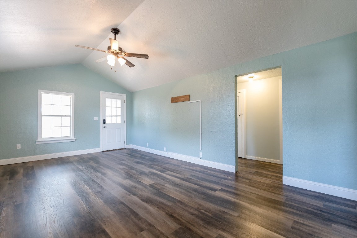 521 N State Avenue, Elk City, OK 73644 empty room featuring vaulted ceiling, ceiling fan, and dark wood-type flooring