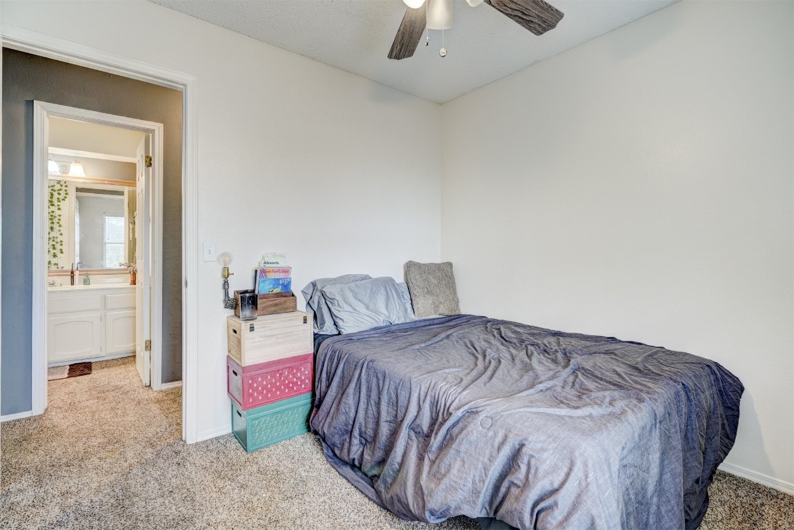 1325 Del Norte Drive, Edmond, OK 73003 bedroom with light carpet, sink, ceiling fan, and ensuite bathroom