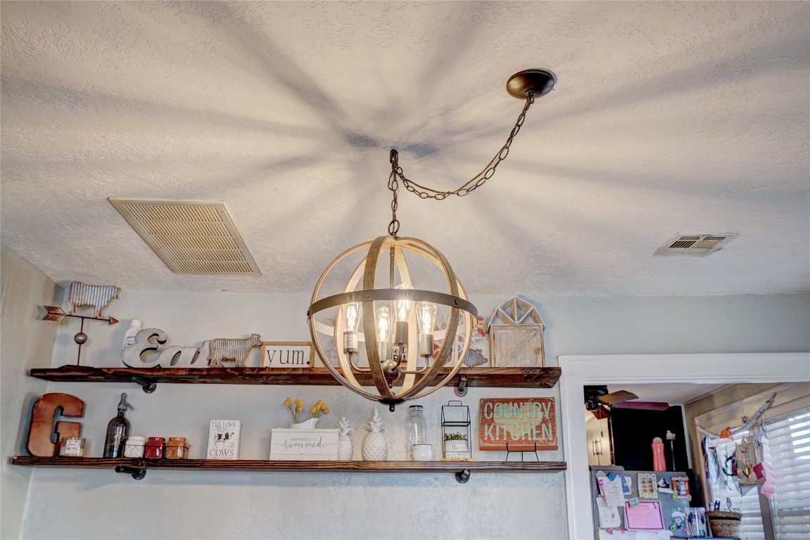 1012 S Williams Avenue, El Reno, OK 73036 details with a notable chandelier, refrigerator, and a textured ceiling