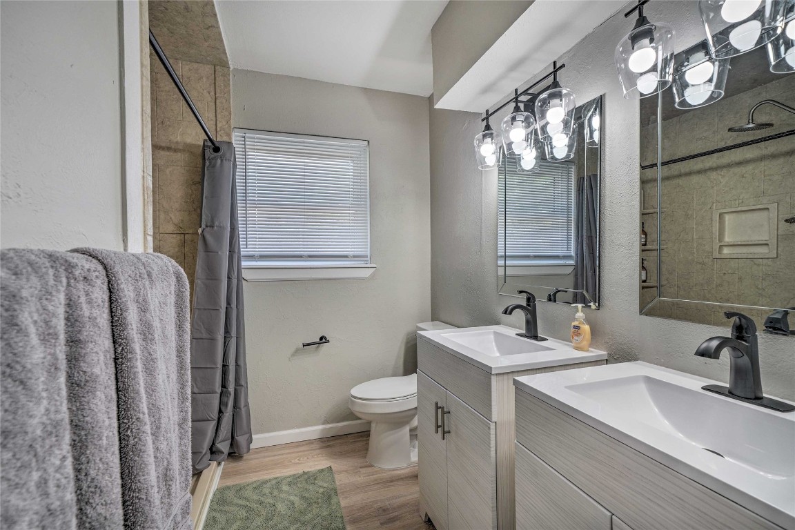 1309 Keystone Lane, Norman, OK 73071 bathroom with a healthy amount of sunlight, wood-type flooring, vanity, and toilet