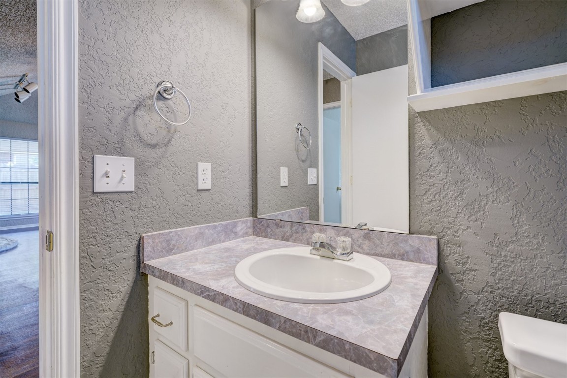 3065 SW 92nd Street, Oklahoma City, OK 73159 bathroom with a textured ceiling, large vanity, and toilet