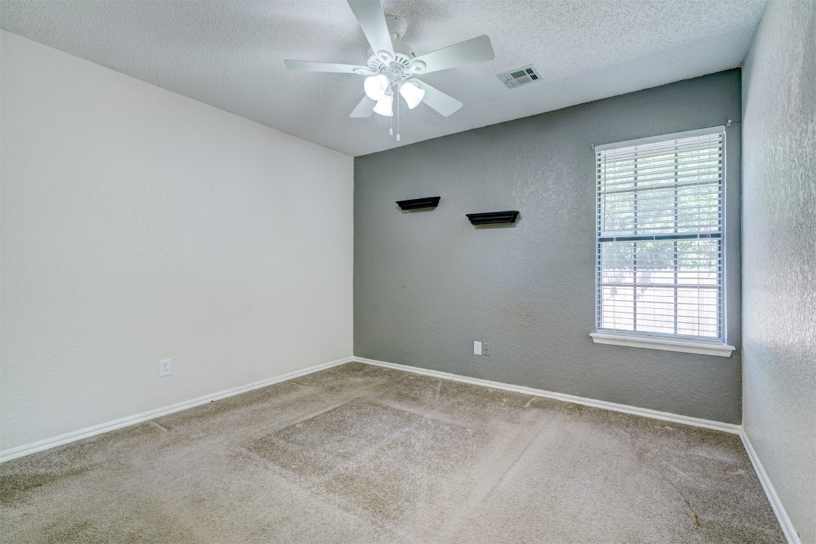 3065 SW 92nd Street, Oklahoma City, OK 73159 carpeted spare room featuring ceiling fan and a textured ceiling