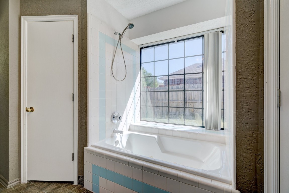 3065 SW 92nd Street, Oklahoma City, OK 73159 bathroom with tile flooring and tiled shower / bath