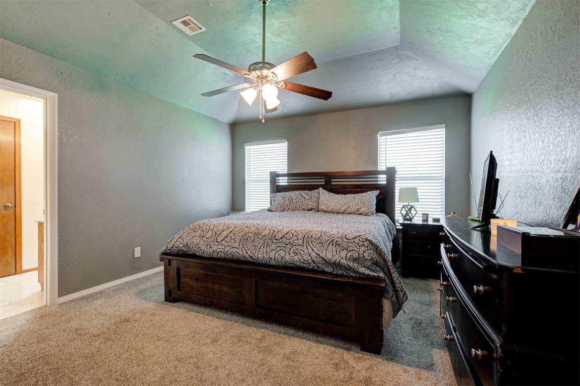 16905 Valley Lane, Edmond, OK 73012 carpeted bedroom featuring ceiling fan and vaulted ceiling