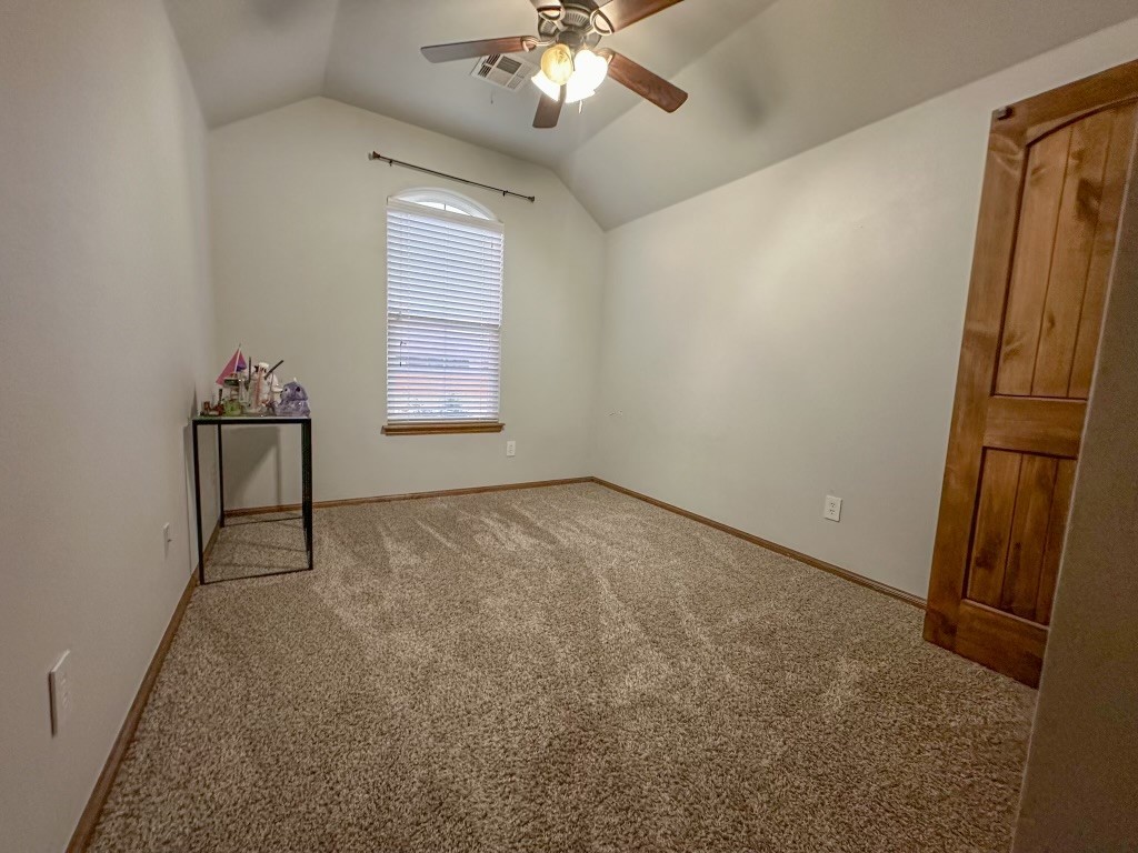 9116 NW 140th Street, Yukon, OK 73099 unfurnished room with carpet floors, ceiling fan, and vaulted ceiling