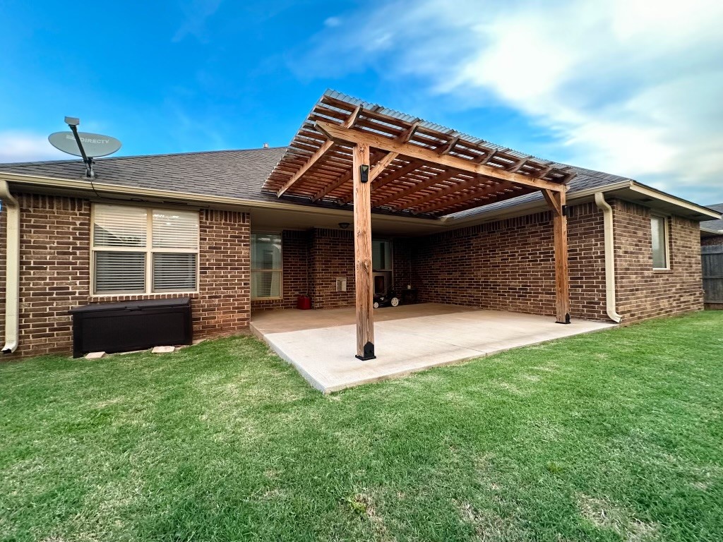 9116 NW 140th Street, Yukon, OK 73099 back of house featuring a pergola, a lawn, and a patio area